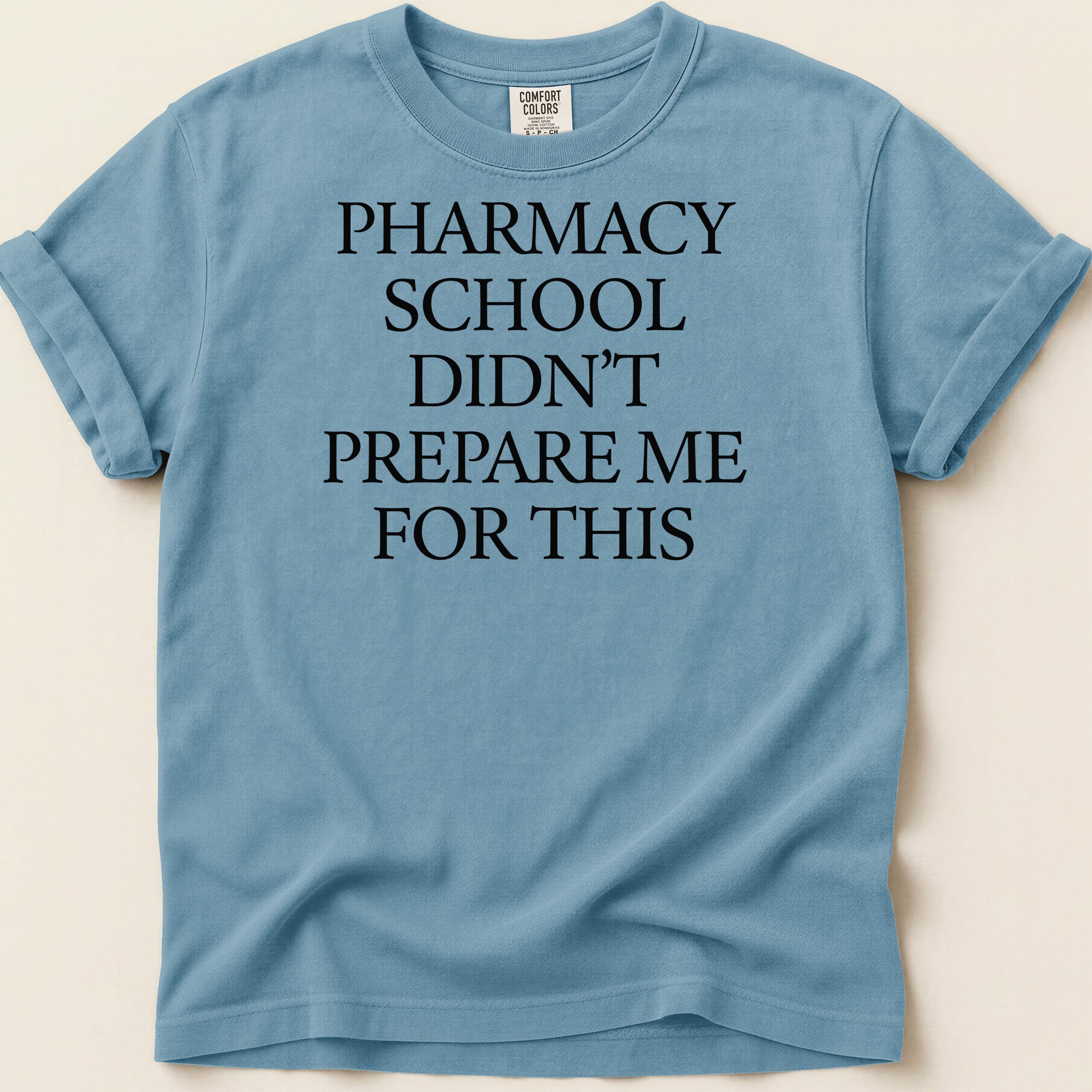Blue t-shirt with black text: "Pharmacy school didn't prepare me for this."
