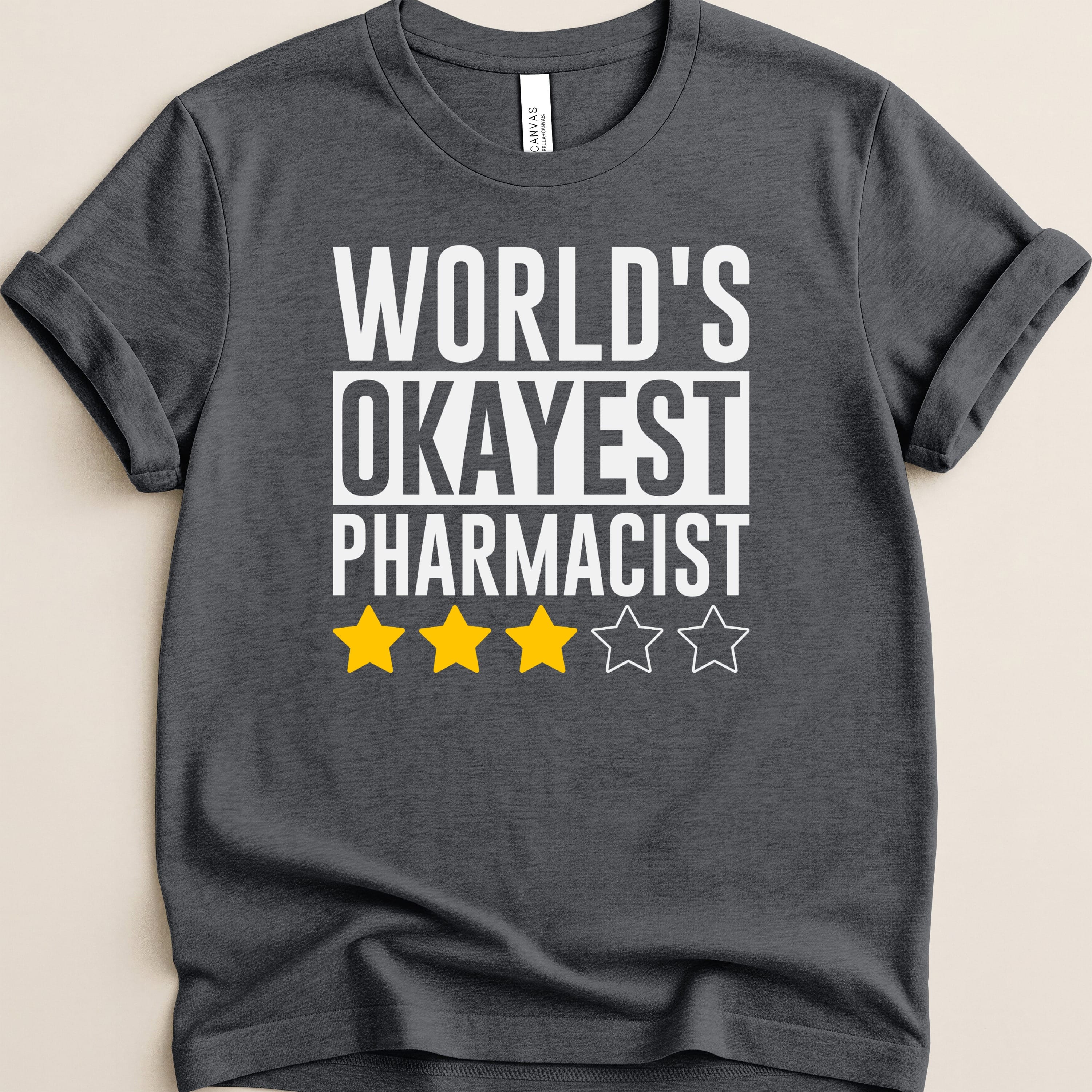 Dark t-shirt with "WORLD'S OKAYEST PHARMACIST" and three stars.
