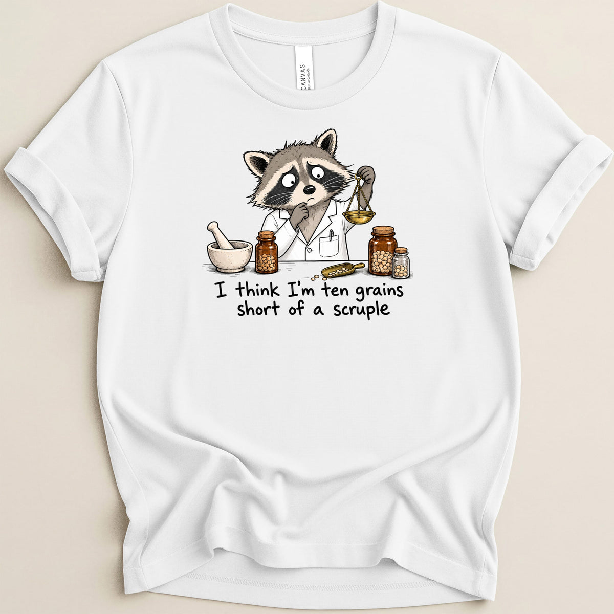White t-shirt with a worried raccoon in a lab coat weighing something.