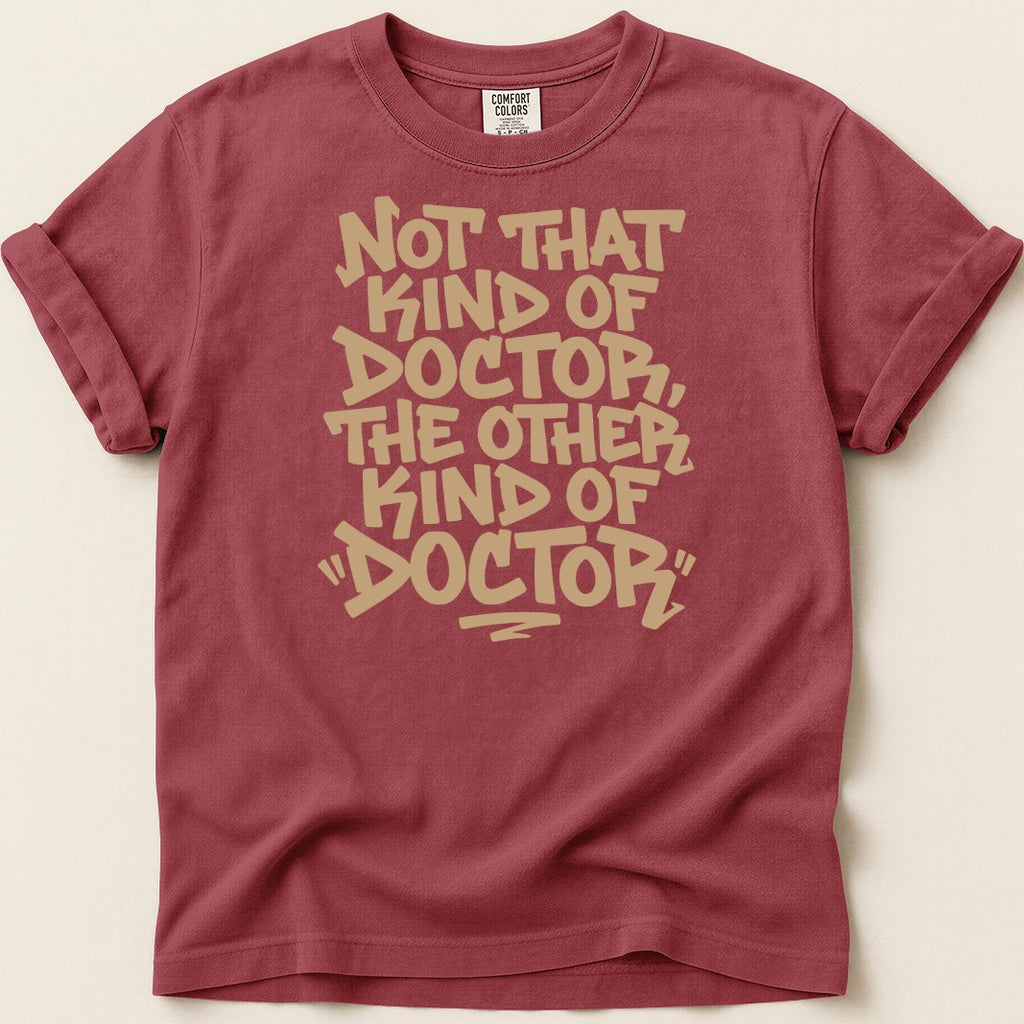 Maroon t-shirt with tan text reading, "Not that kind of doctor, the other kind of doctor."