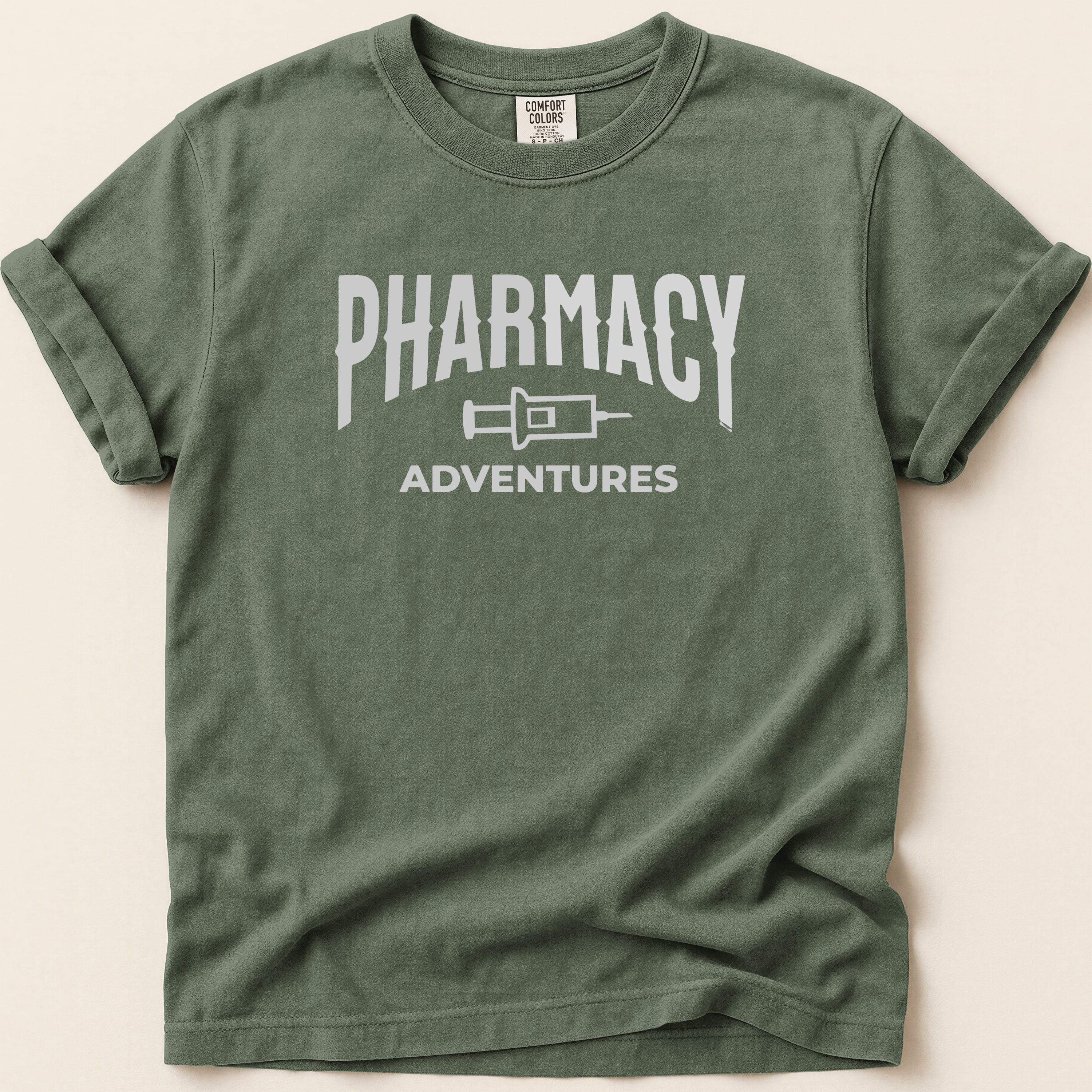 Green t-shirt with "Pharmacy Adventures" graphic in white.