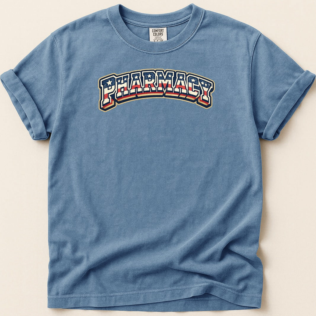 Blue t-shirt with "Pharmacy" text in red, white, and blue arched design.