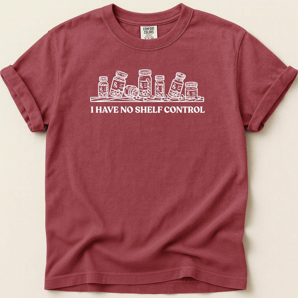 Maroon t-shirt with a white graphic of pill bottles and the text "I HAVE NO SHELF CONTROL".