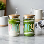 Two glasses with "PHARMACY" text and straws, one with matcha, one with layered drink.