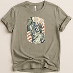 Statue of Liberty holding mortar and pestle with fireworks and flag.