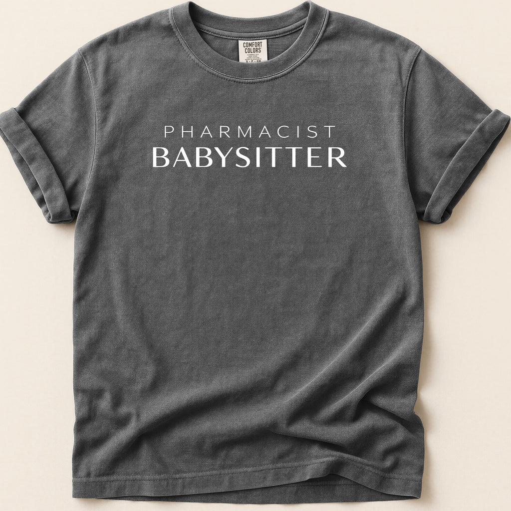 Dark gray t-shirt with white text "PHARMACIST BABYSITTER".