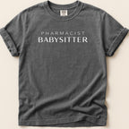 Dark gray t-shirt with white text "PHARMACIST BABYSITTER".