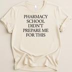 Cream t-shirt with "Pharmacy School Didn't Prepare Me For This" text.
