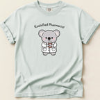 T-shirt with cartoon koala wearing lab coat holding Rx bottle, text "Koalafied Pharmacist".