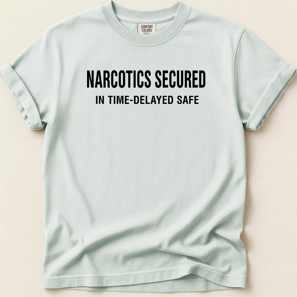 Light blue t-shirt with black text "NARCOTICS SECURED IN TIME-DELAYED SAFE".