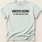 Light blue t-shirt with black text "NARCOTICS SECURED IN TIME-DELAYED SAFE".
