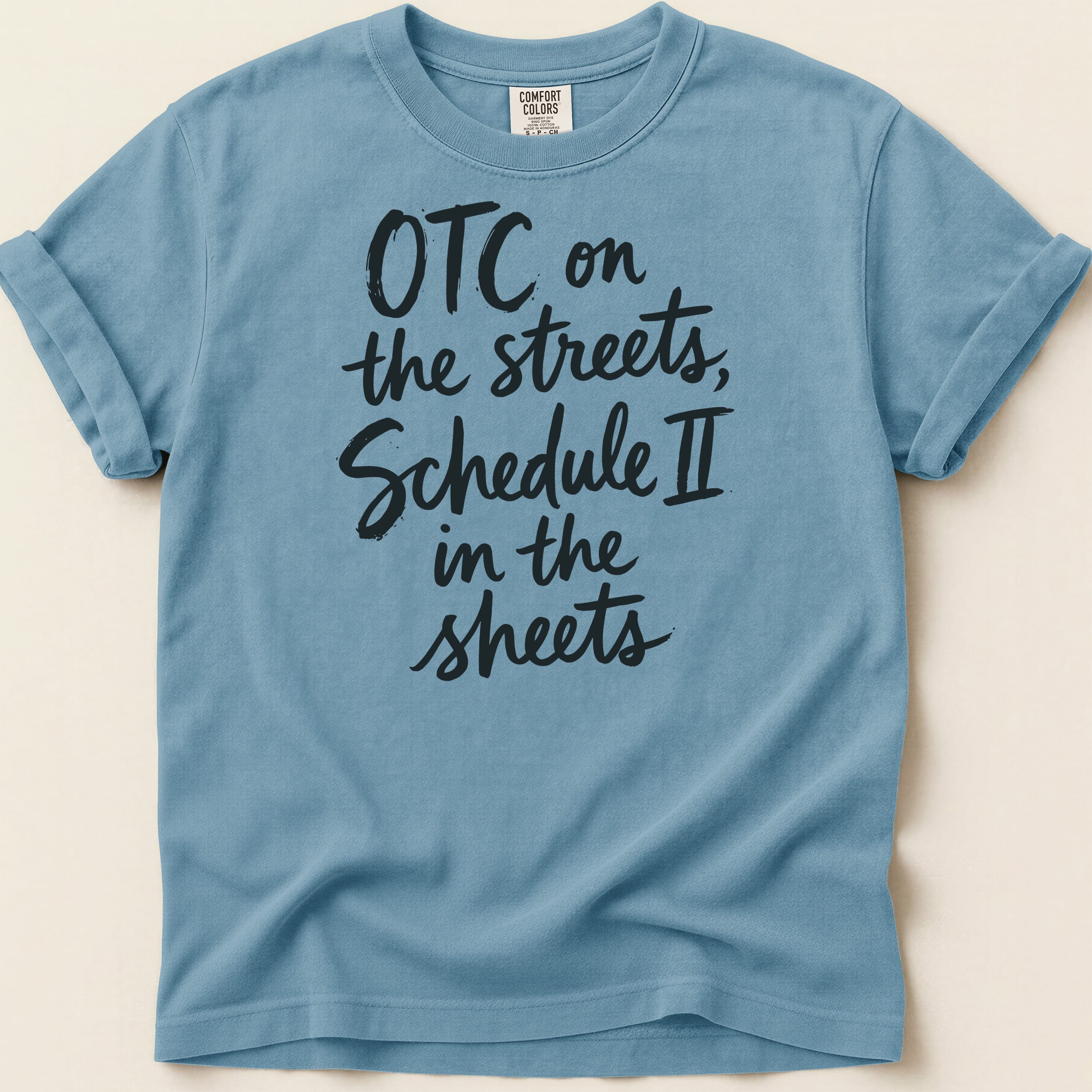Blue t-shirt with black text reading "OTC on the streets, Schedule II in the sheets".