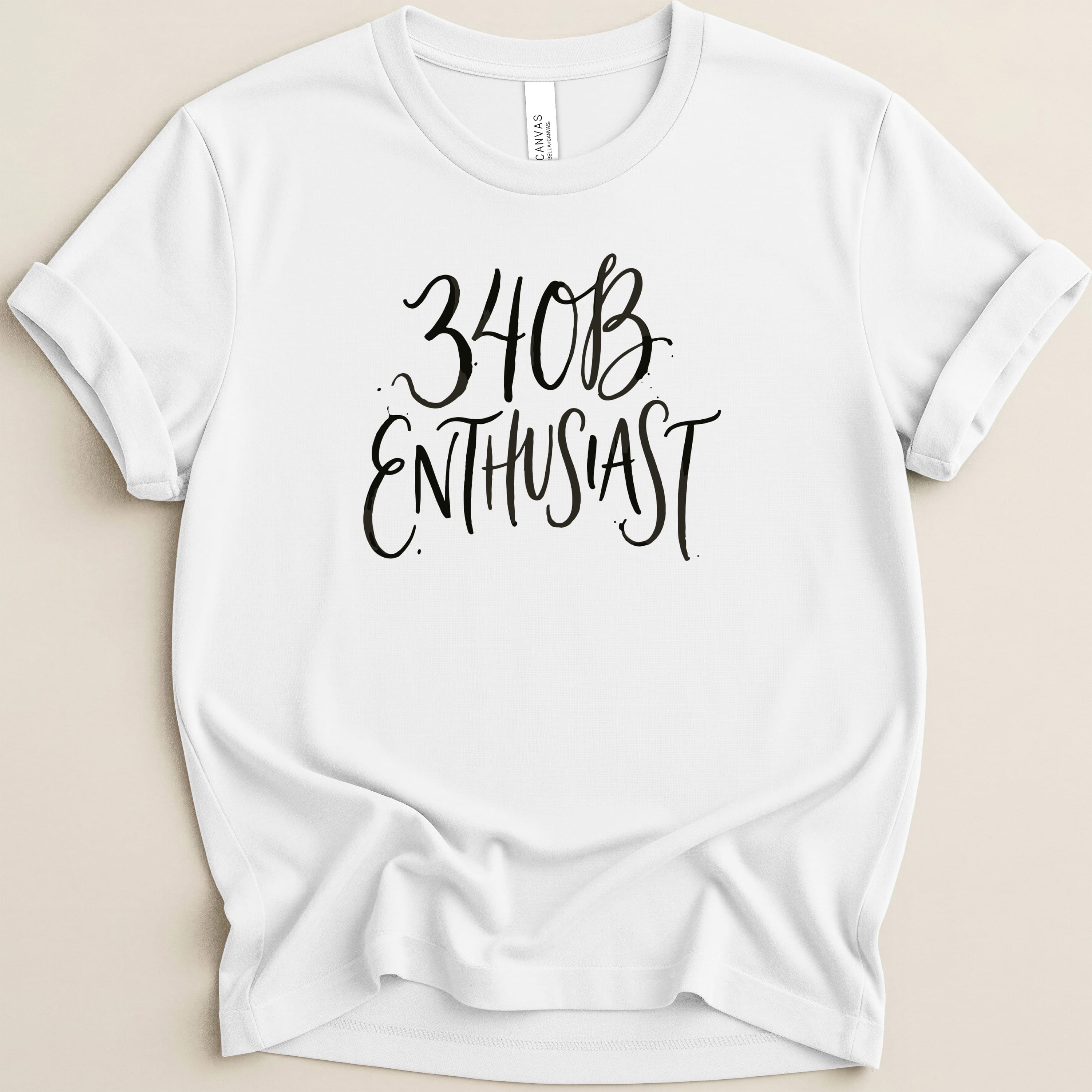 White t-shirt with "34B Enthusiast" in black script lettering.
