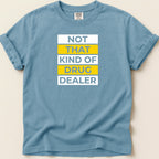 Blue t-shirt with white text "NOT THAT KIND OF DRUG DEALER" in yellow and blue.