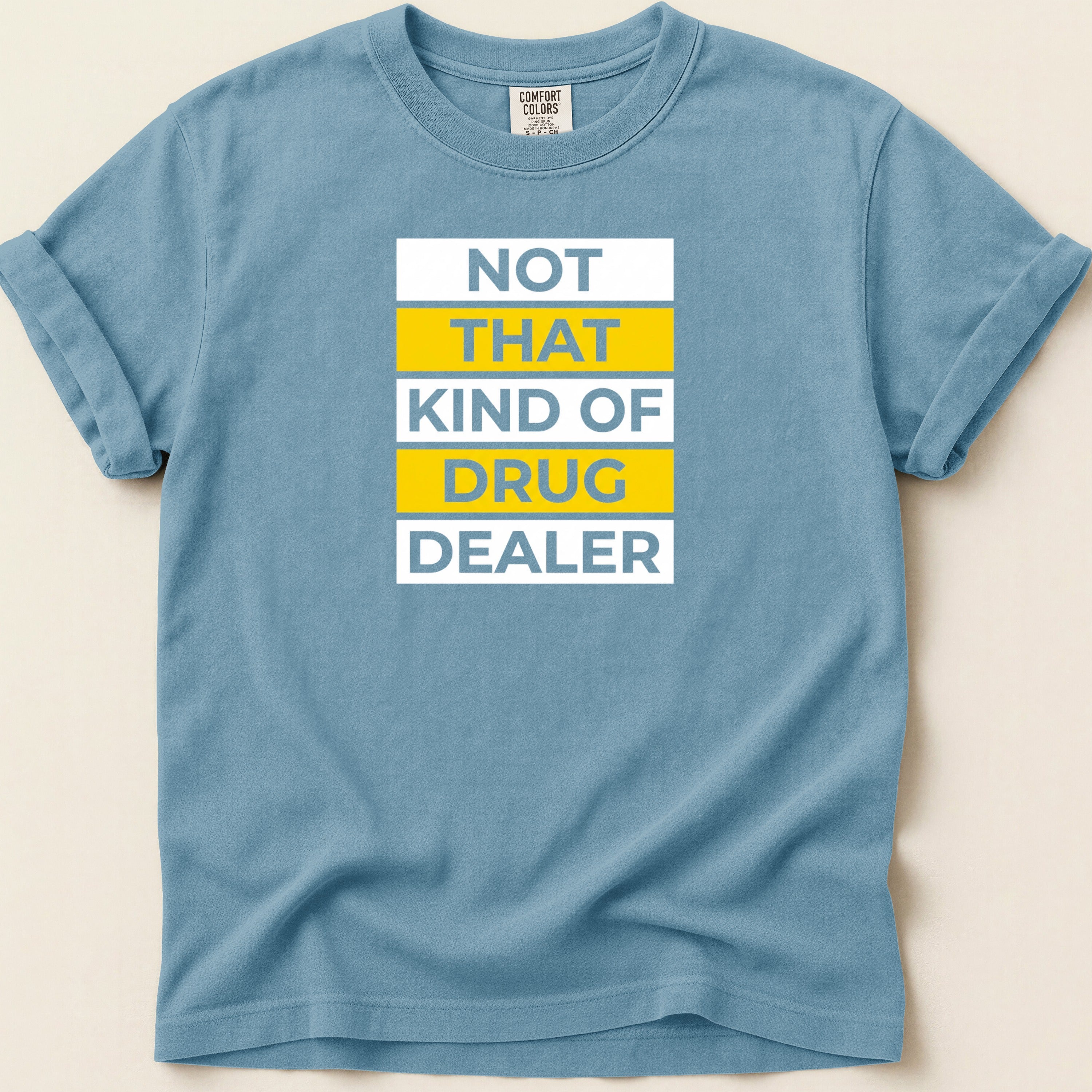 Blue t-shirt with white text "NOT THAT KIND OF DRUG DEALER" in yellow and blue.