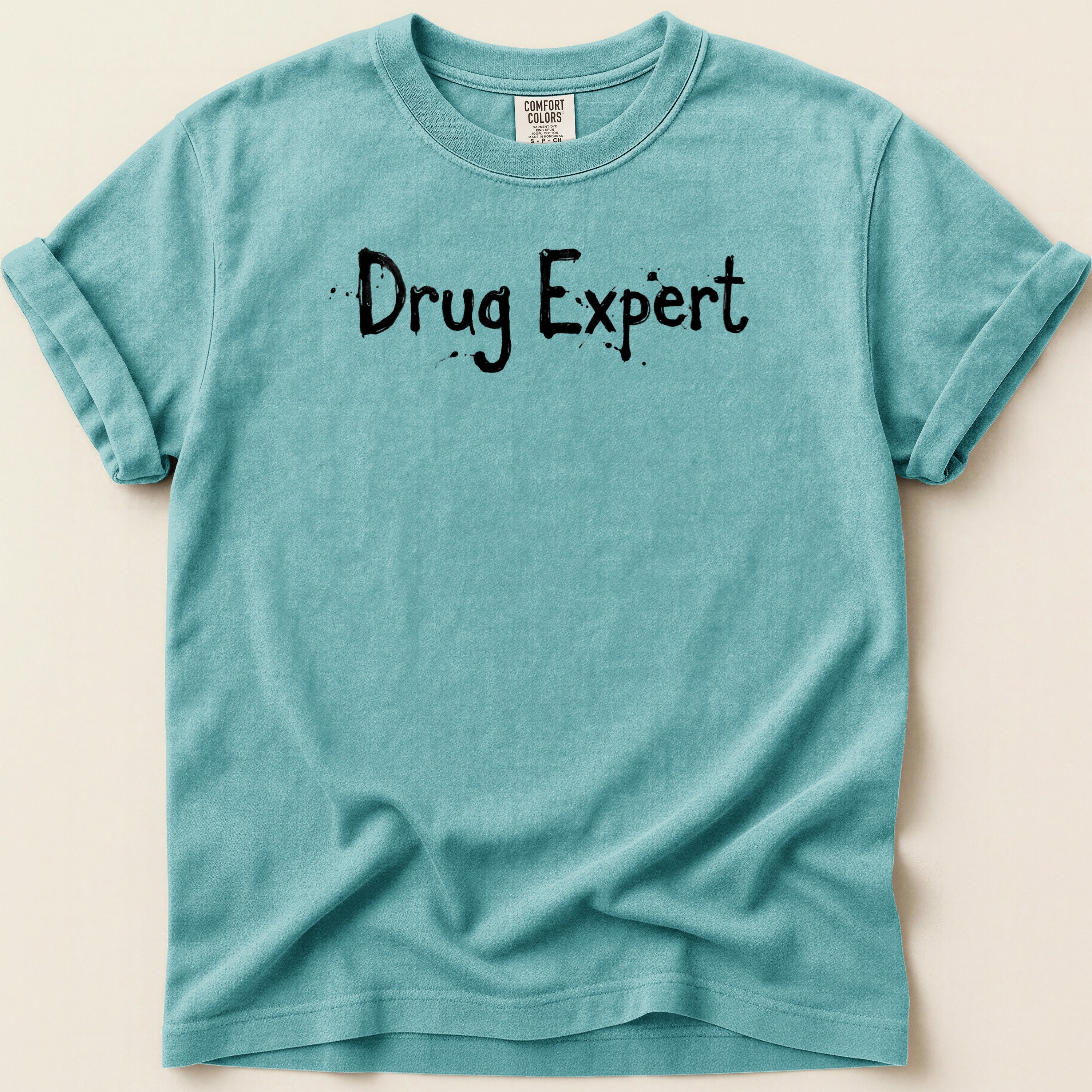 Teal t-shirt with "Drug Expert" printed in black, distressed lettering.