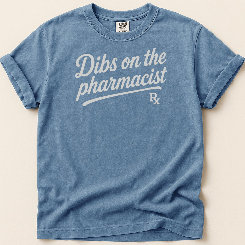 Blue t-shirt with white text "Dibs on the pharmacist" and Rx symbol.