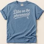 Blue t-shirt with white text "Dibs on the pharmacist" and Rx symbol.