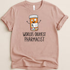 T-shirt with cartoon pill bottle and text "World's Okayest Pharmacist".