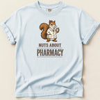 Light blue t-shirt with a squirrel wearing a lab coat holding a pill bottle, text reads "NUTS ABOUT PHARMACY".
