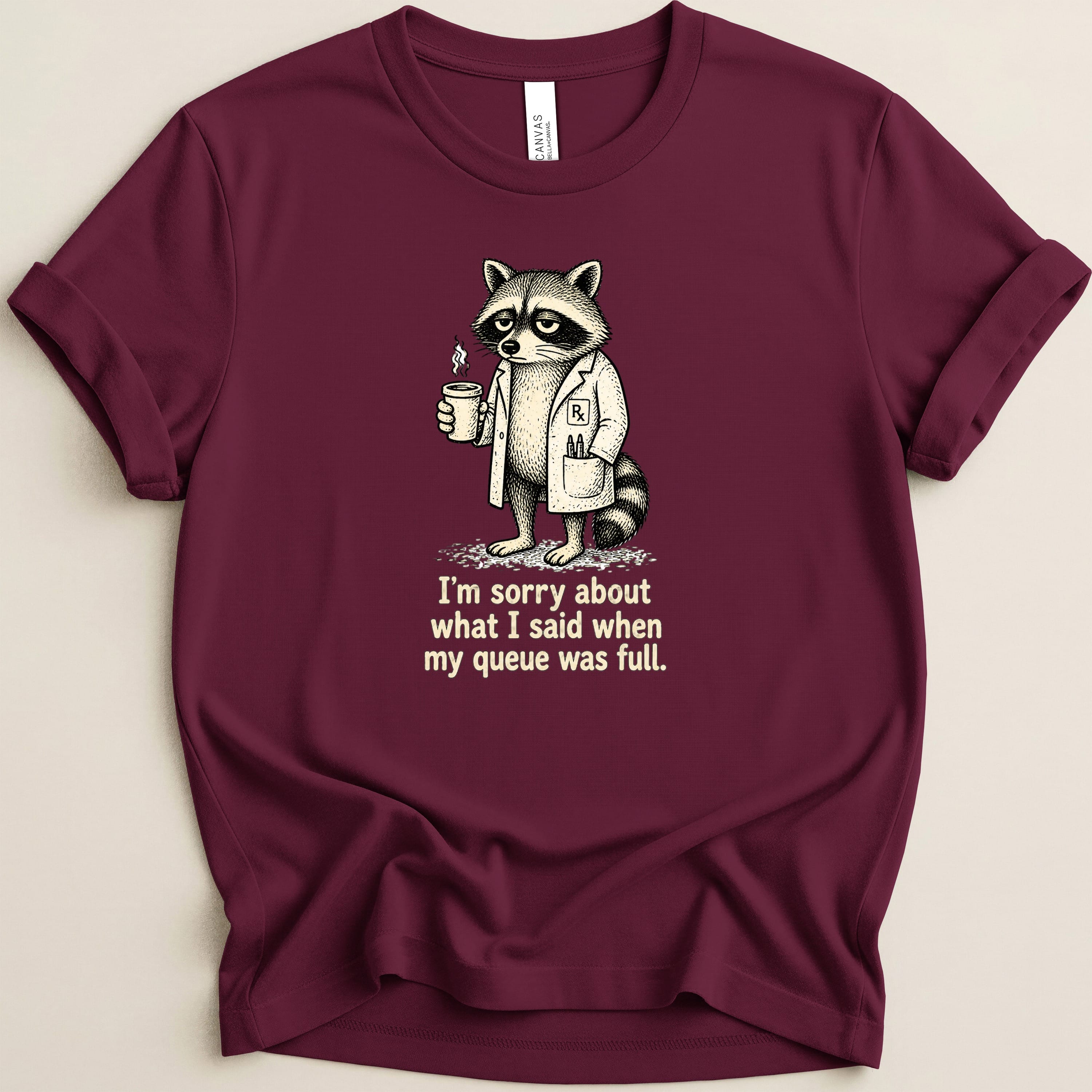 T-shirt graphic of a raccoon in a lab coat holding coffee, with text.