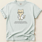 Light blue t-shirt with a cartoon cat in a lab coat wearing glasses, text reads "pharmacologically speaking, i exhibit time-dependent toxicity."
