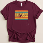 Maroon t-shirt with distressed "INDISPENSABLE" text on a vintage striped background.