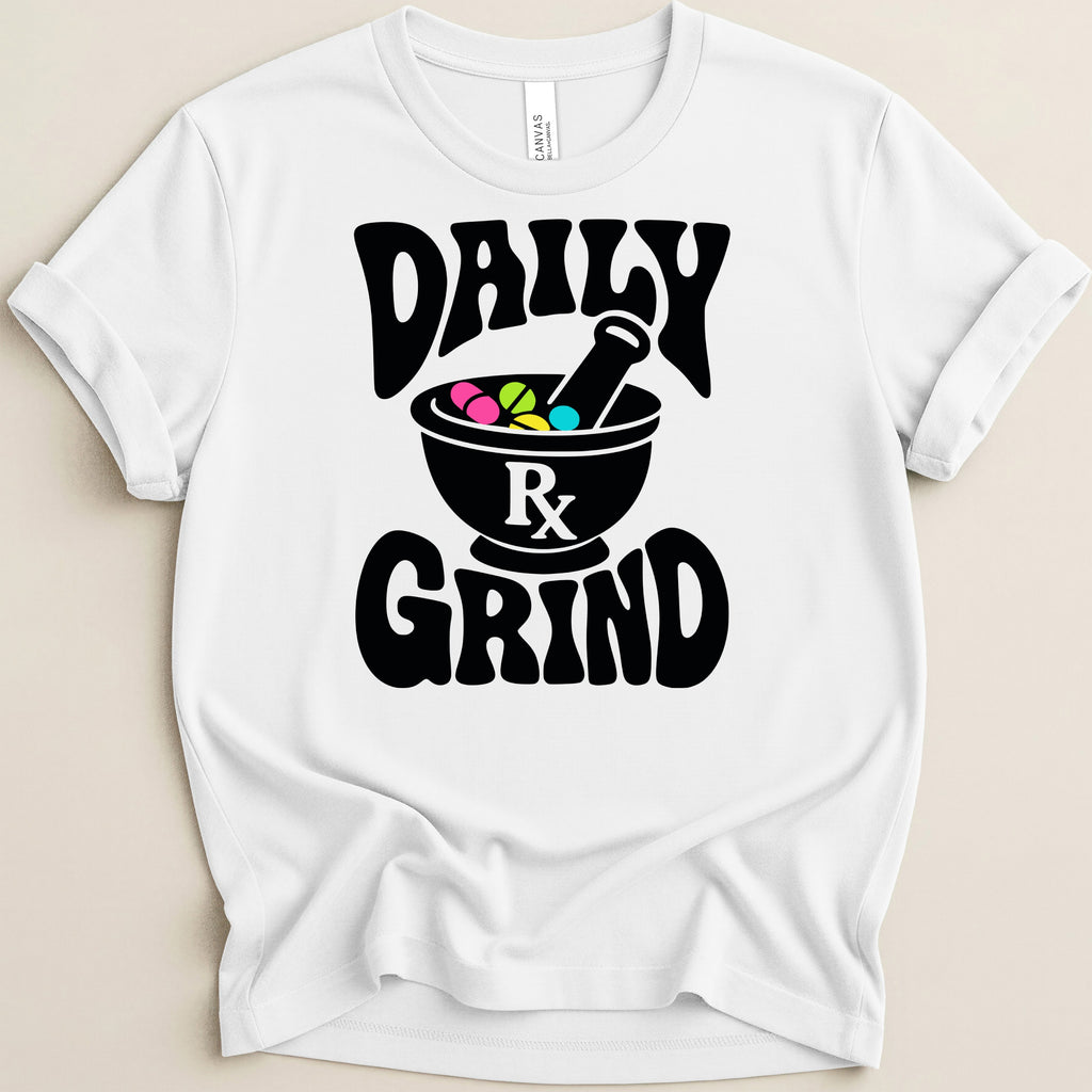 White t-shirt with black text "DAILY GRIND" and a mortar and pestle with pills.