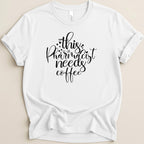 White t-shirt with black text: "this pharmacist needs coffee".
