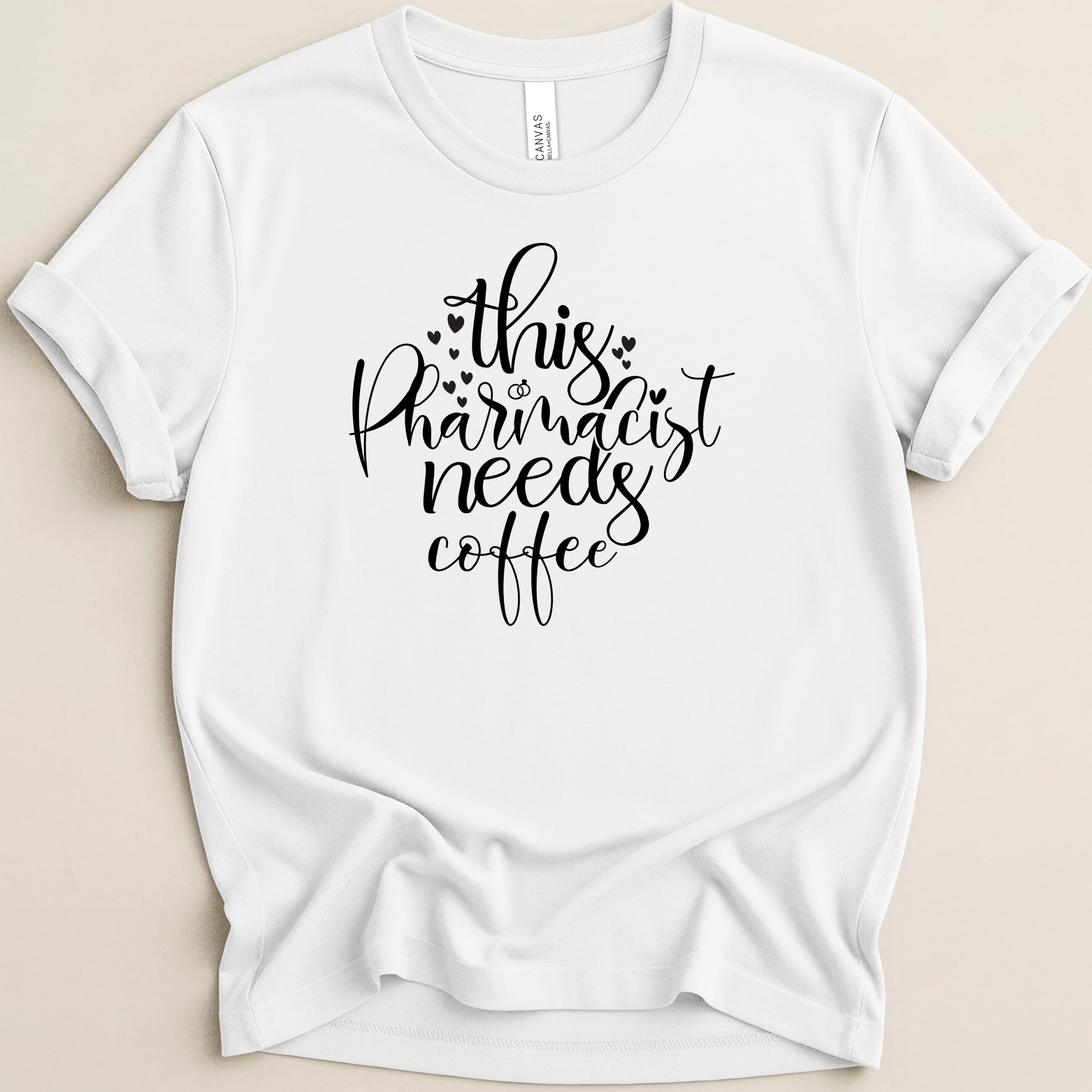 White t-shirt with black text: "this pharmacist needs coffee".