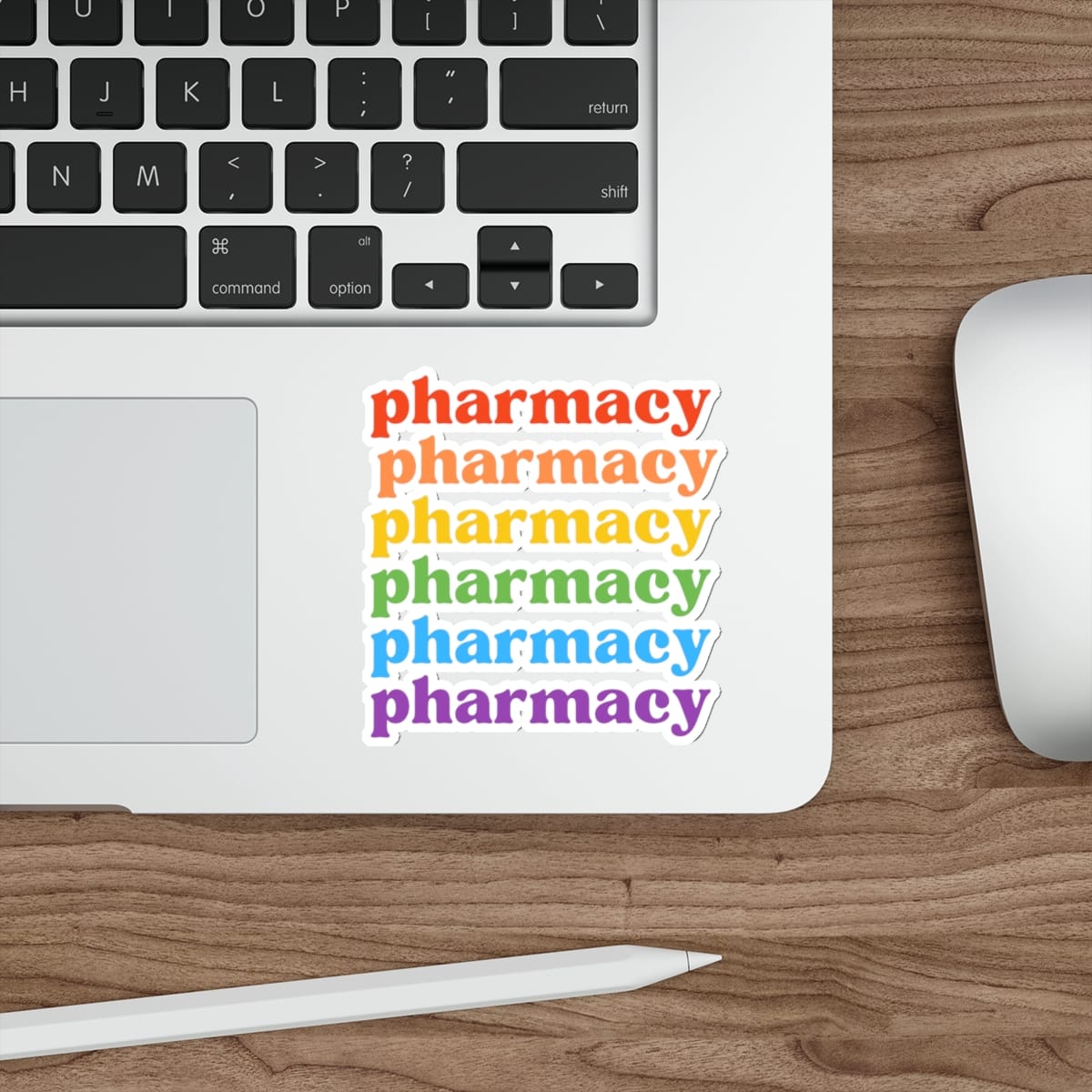 Rainbow sticker with "pharmacy" repeated six times across a laptop keyboard.