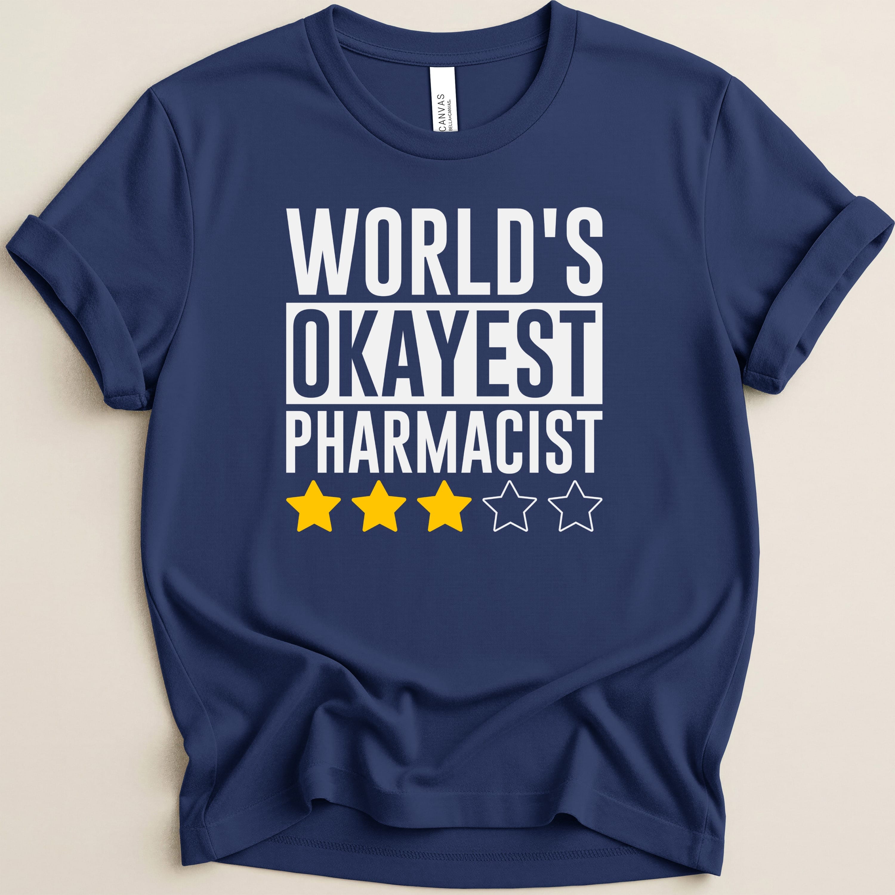 Navy t-shirt with "World's Okayest Pharmacist" and three yellow stars.