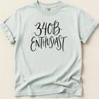 Light blue t-shirt with black script text reading "340B ENTHUSIAST".