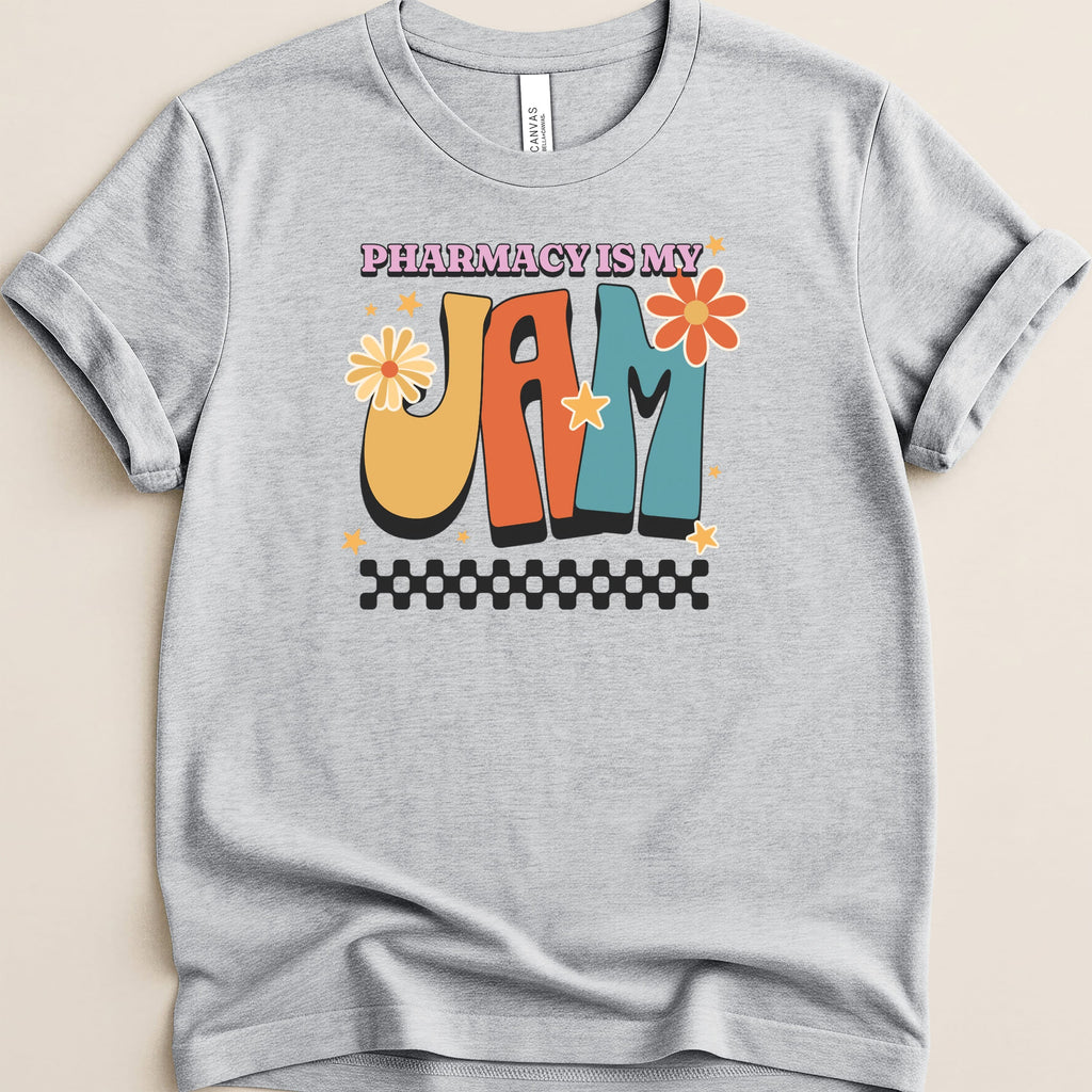 "Pharmacy is my jam" text with retro font and floral accents on a gray t-shirt.