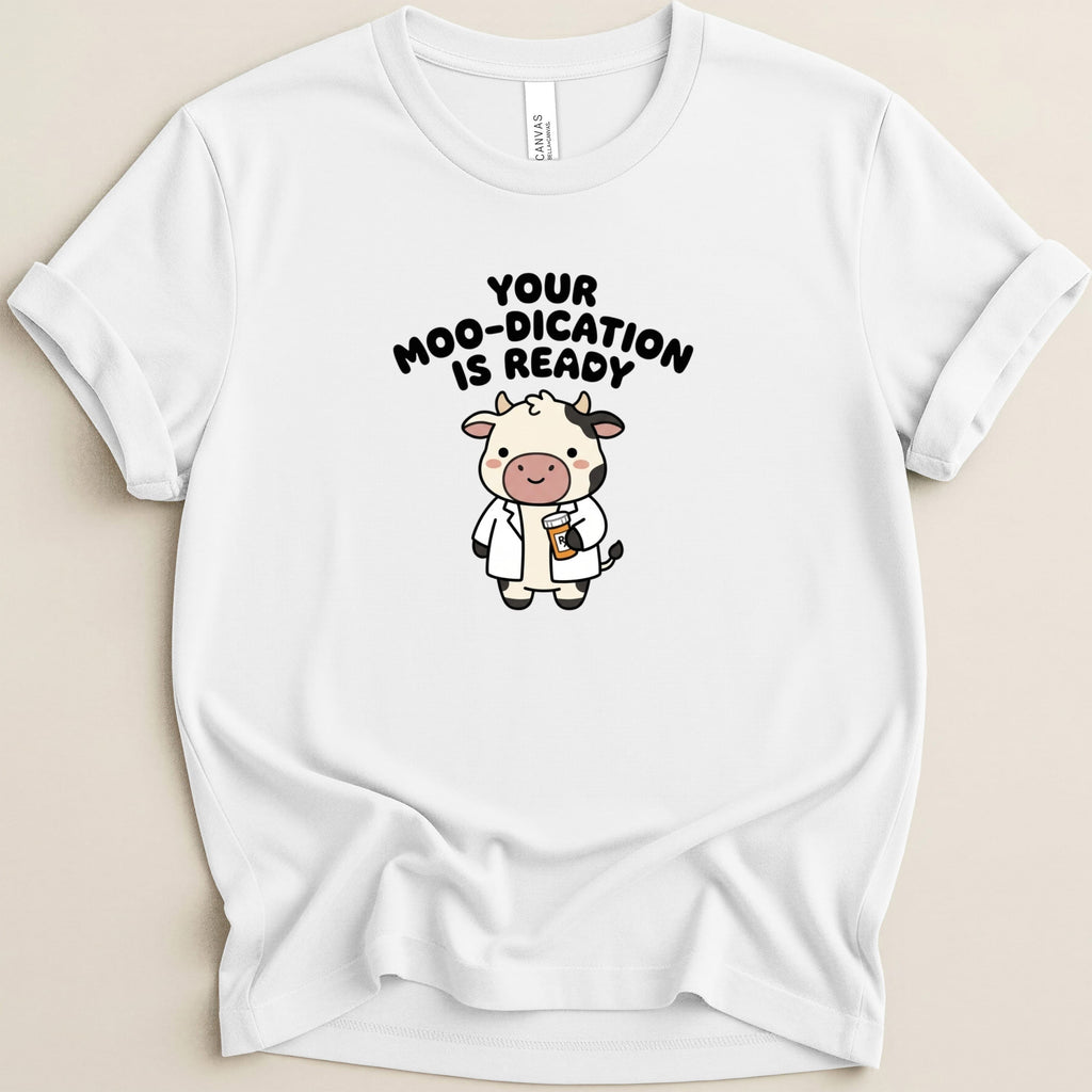 White t-shirt with cartoon cow doctor holding a cup, text reads "Your moo-dication is ready".