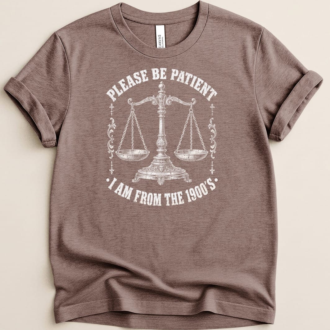 Brown t-shirt with white graphic of a scale and text "PLEASE BE PATIENT I AM FROM THE 1900'S".