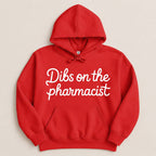 Red hoodie with "Dibs on the pharmacist" in white cursive text.