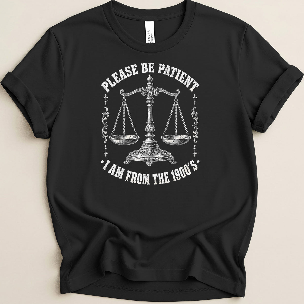 Black t-shirt with scales of justice and text "Please be patient I am from the 1900's".