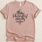 Peach t-shirt with "this pharmacist needs coffee" in black script.