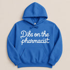 Royal blue hoodie with "Dibs on the pharmacist" in white cursive text.
