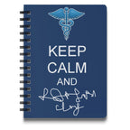 Notebook with Caduceus, "Keep Calm," and signature on blue cover.