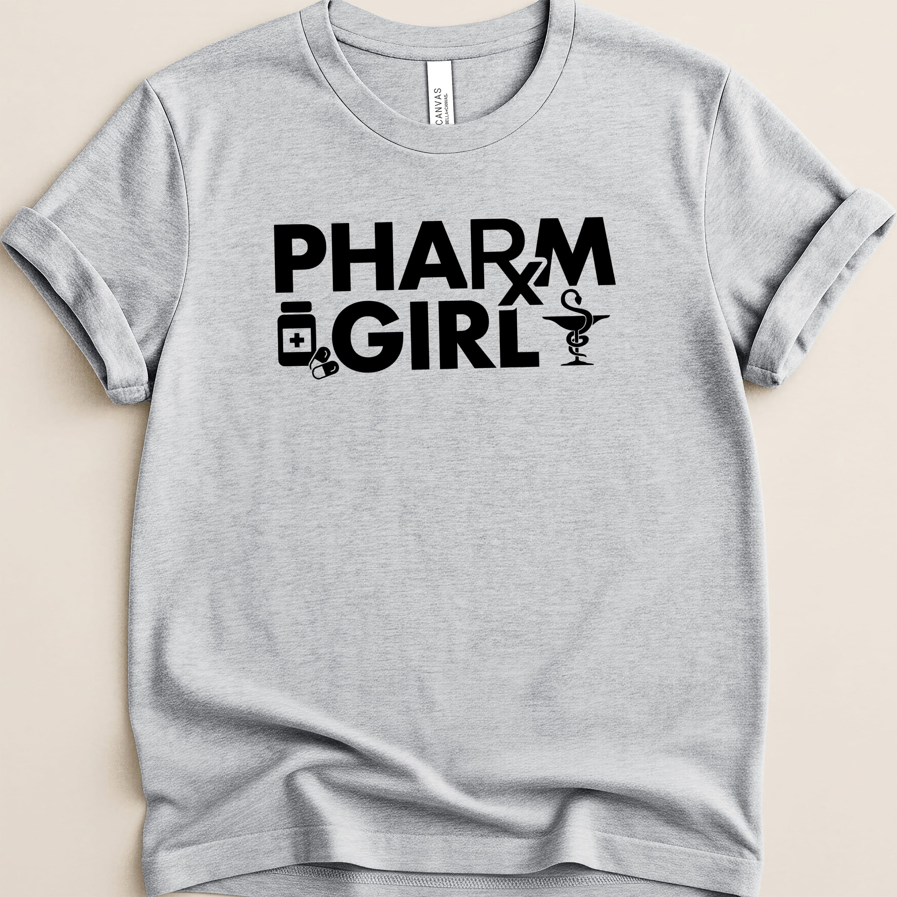 Gray t-shirt with black text "PHARM GIRL" and medical icons.