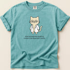 Teal t-shirt with cartoon cat wearing lab coat and glasses, text reads: "pharmacologically speaking, i exhibit time-dependent toxicity."