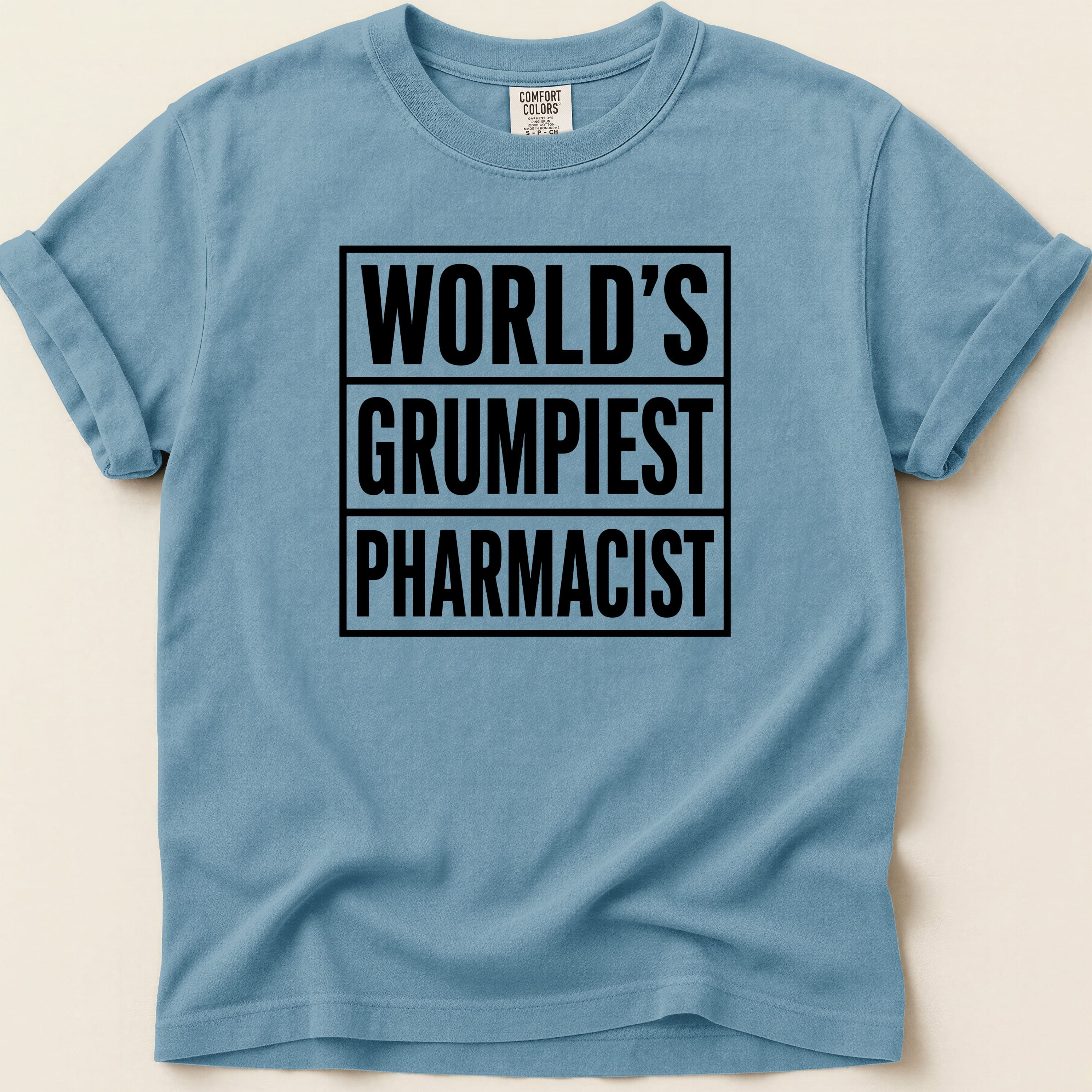 Blue t-shirt with "WORLD'S GRUMPIEST PHARMACIST" in bold black text.