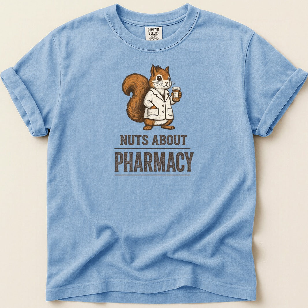 Light blue t-shirt with a squirrel in a lab coat holding a cup, text reads "Nuts About Pharmacy".