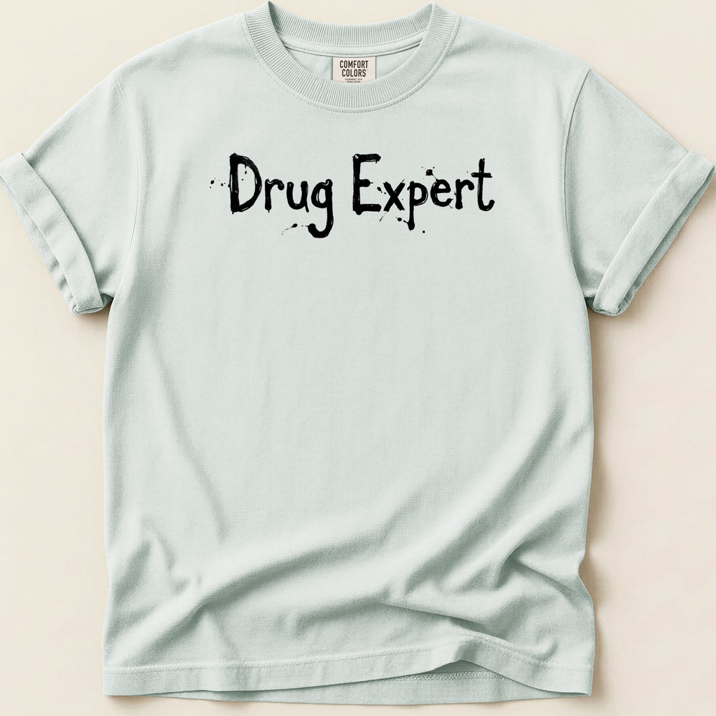 Light blue t-shirt with black speckled text reading "Drug Expert".