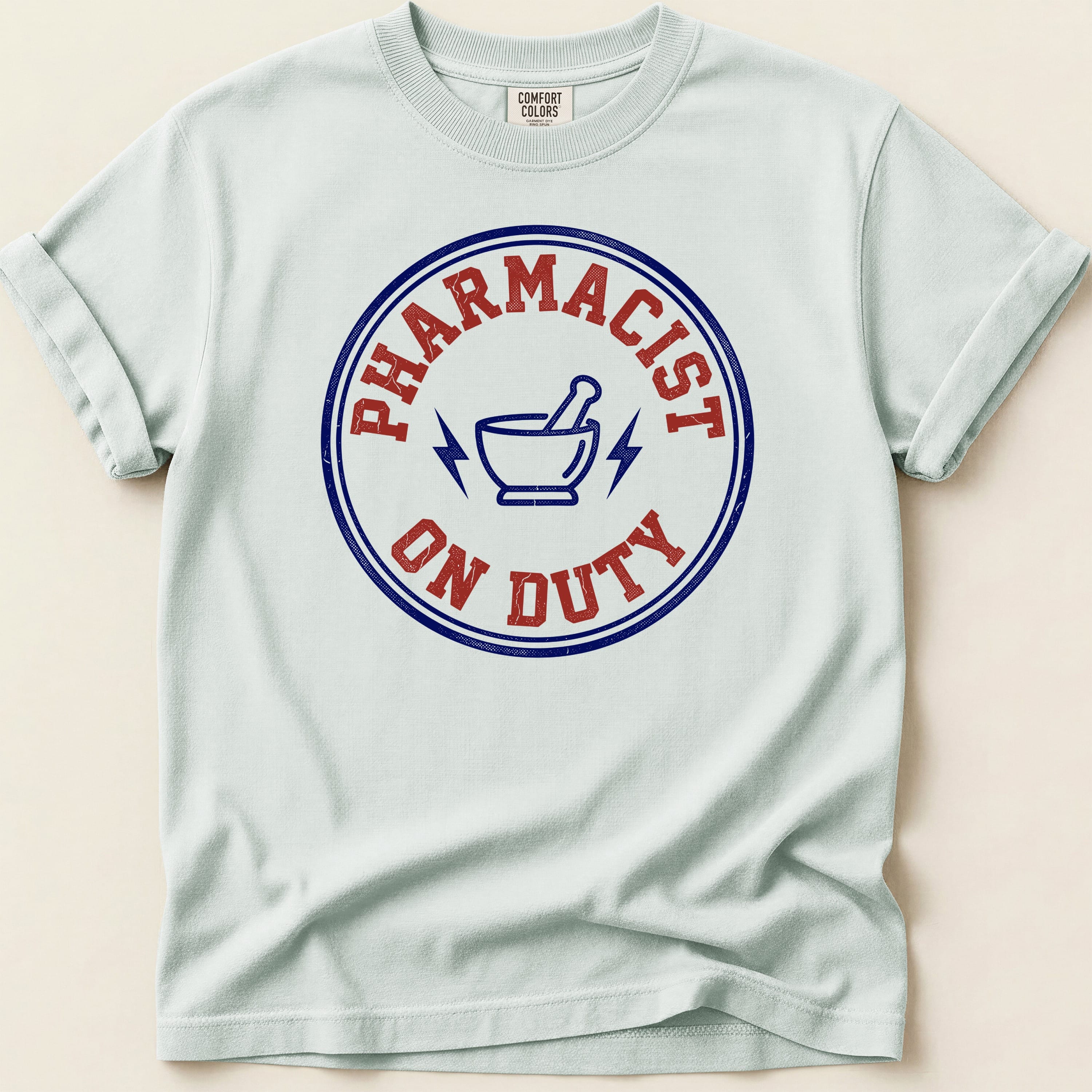 Light blue t-shirt with "Pharmacist On Duty" text and lightning bolt logo.
