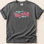 T-shirt with "DRUG DEALER" text in wavy pink and blue lettering.