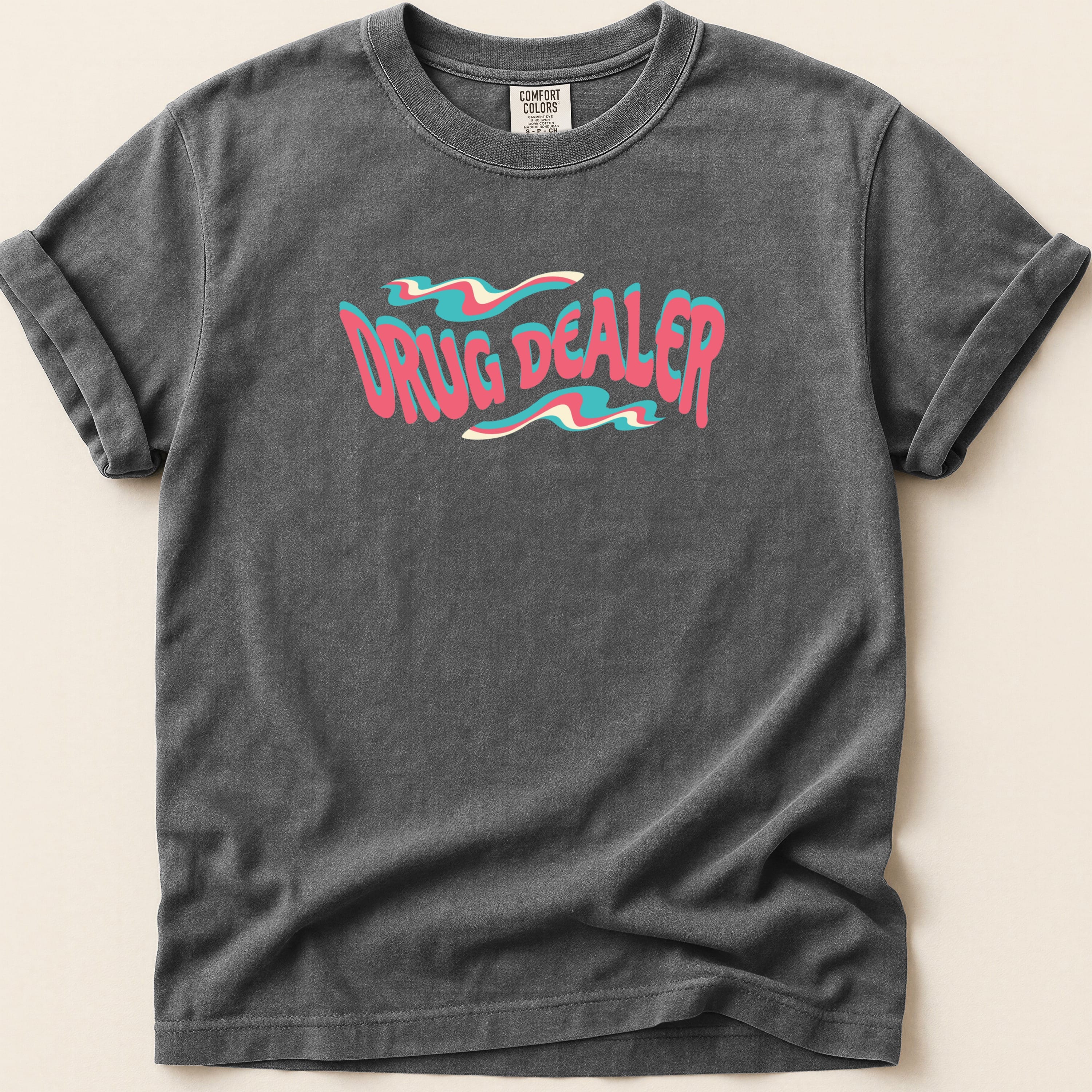 T-shirt with "DRUG DEALER" text in wavy pink and blue lettering.