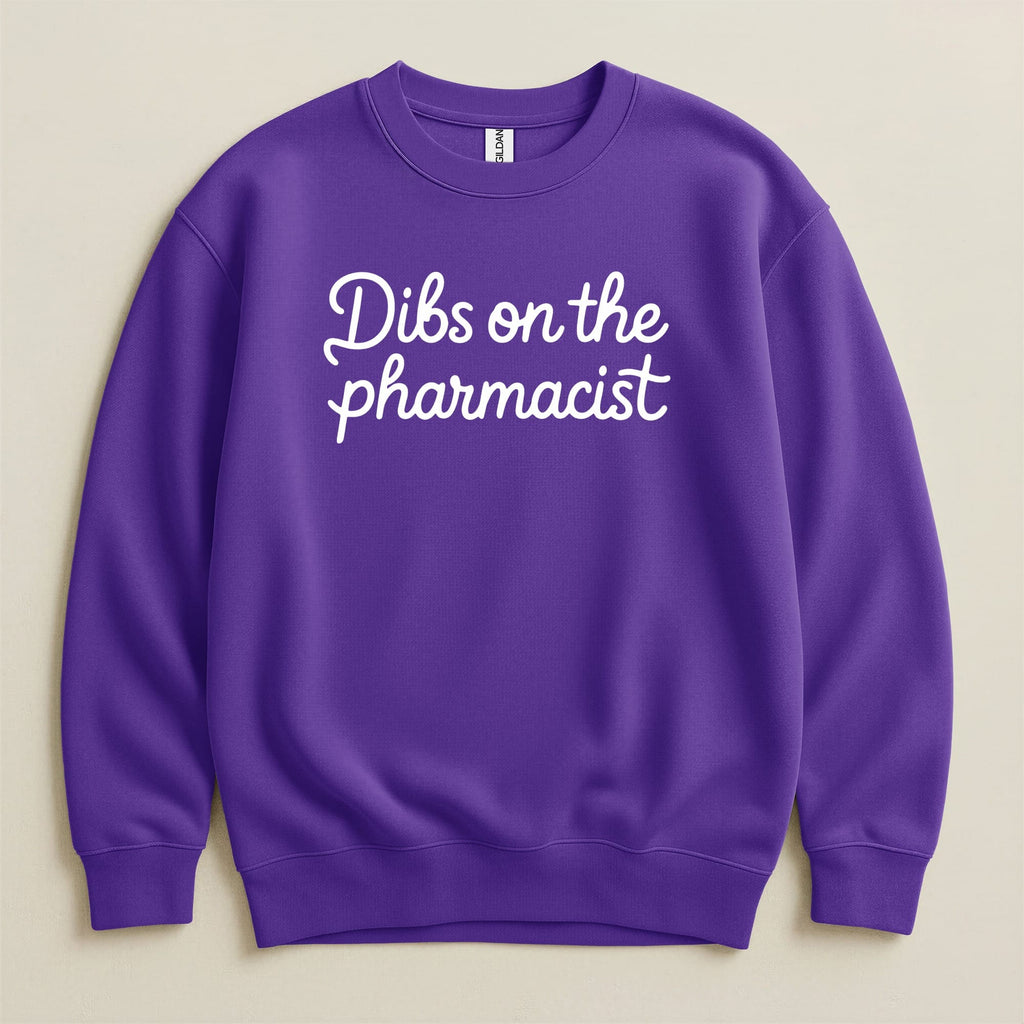 Purple Gildan sweatshirt with white text that says "Dibs on the pharmacist".